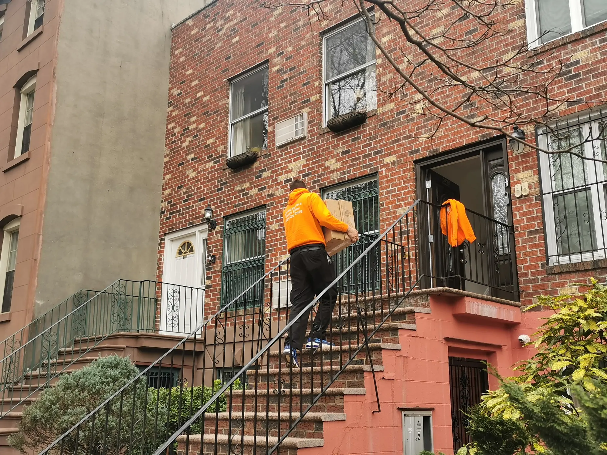 queens-movers-walkup Movers in Queens carrying boxes up apartment walk-up